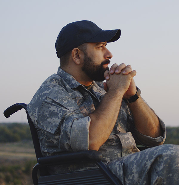 Medium shot of a wheelchaired soldier looking away into the distance